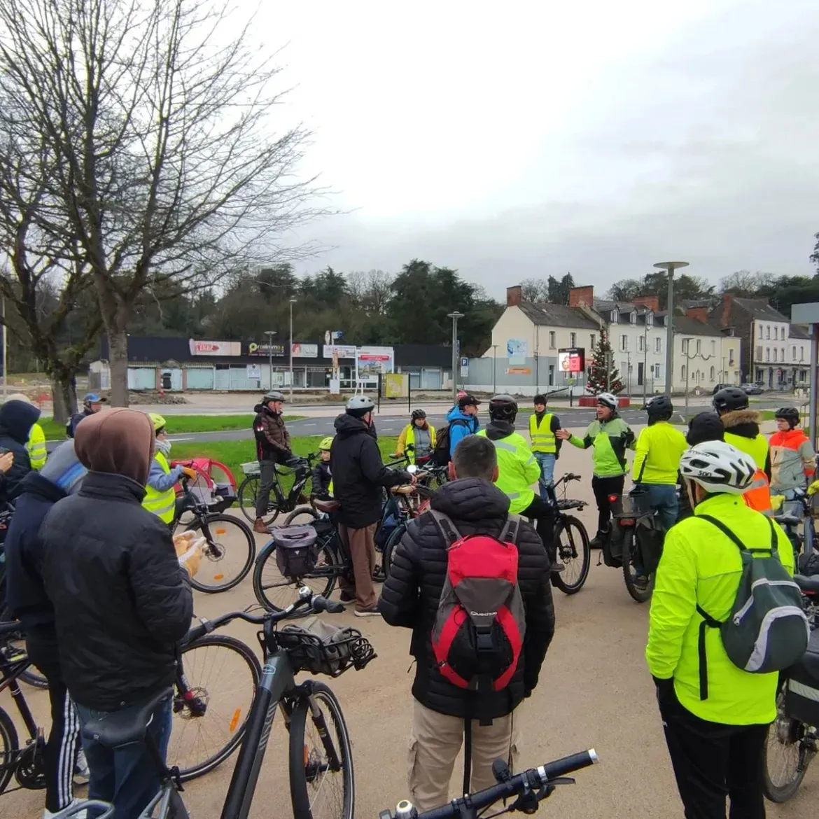 Des cyclistes en gilet jaune rassemblés avec leurs vélos avant le départ de la balade
