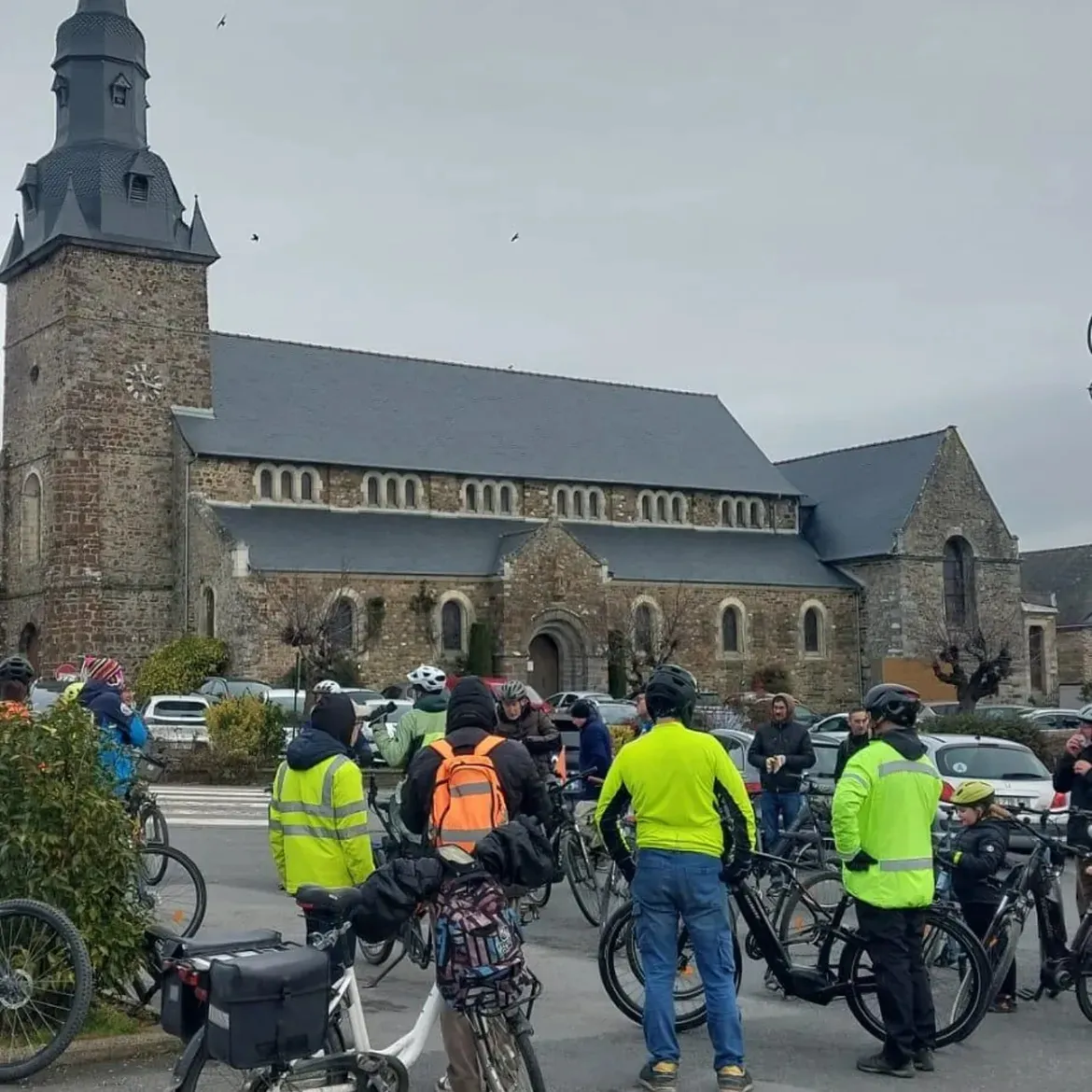 Les cyclistes rassemblés sur la place, devant l'église