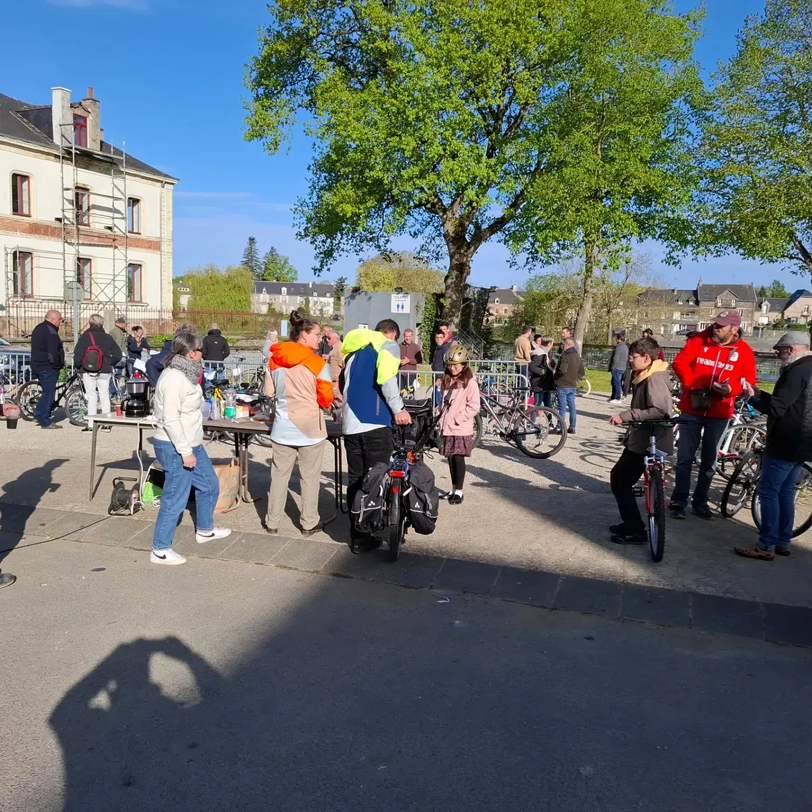 Le stand de l'association et des visiteurs avec leurs vélos, au soleil