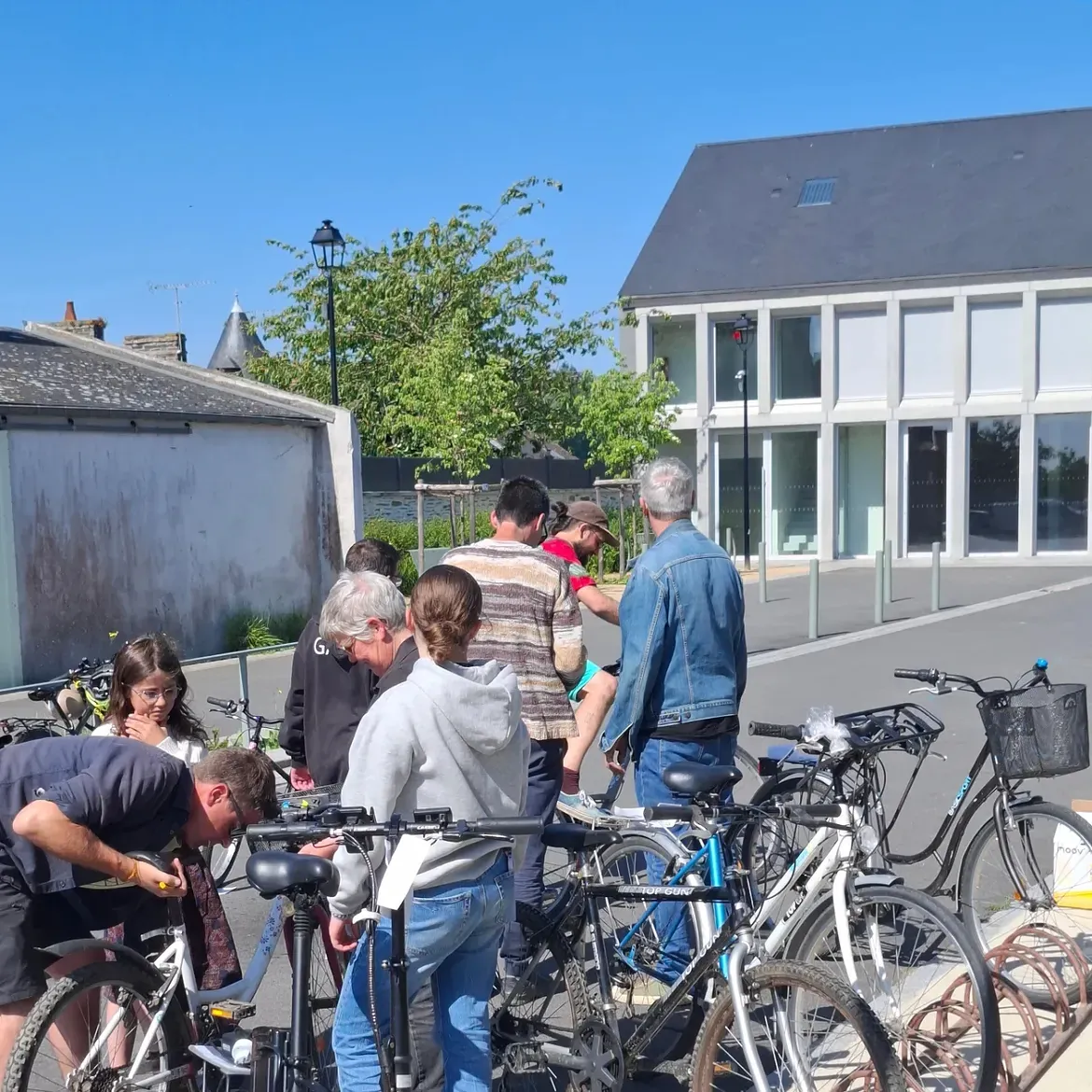 Des visiteurs examinent les vélos exposés devant un bâtiment moderne
