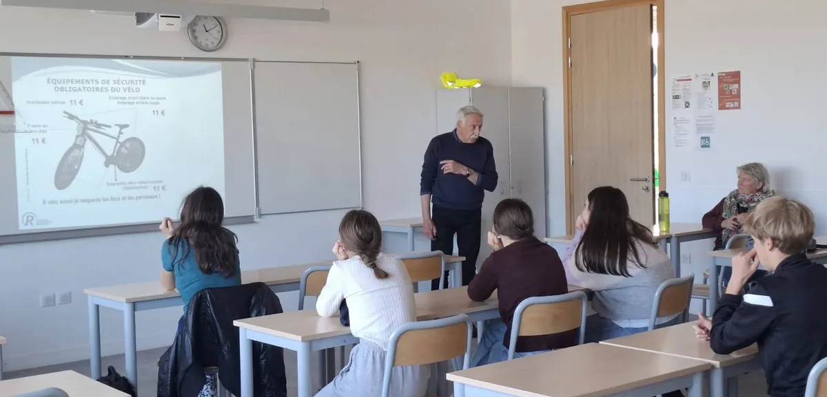 Un intervenant devant le tableau où est projeté un schéma de vélo, face aux élèves