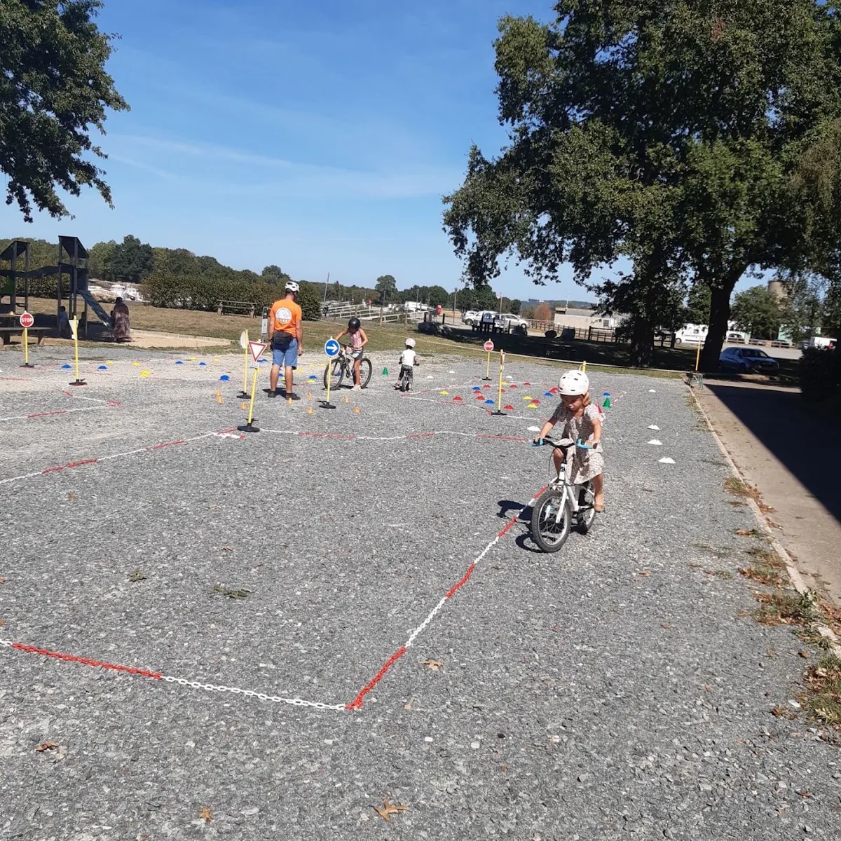 Des enfants à vélo dans le slalom entre les piquets et les plots